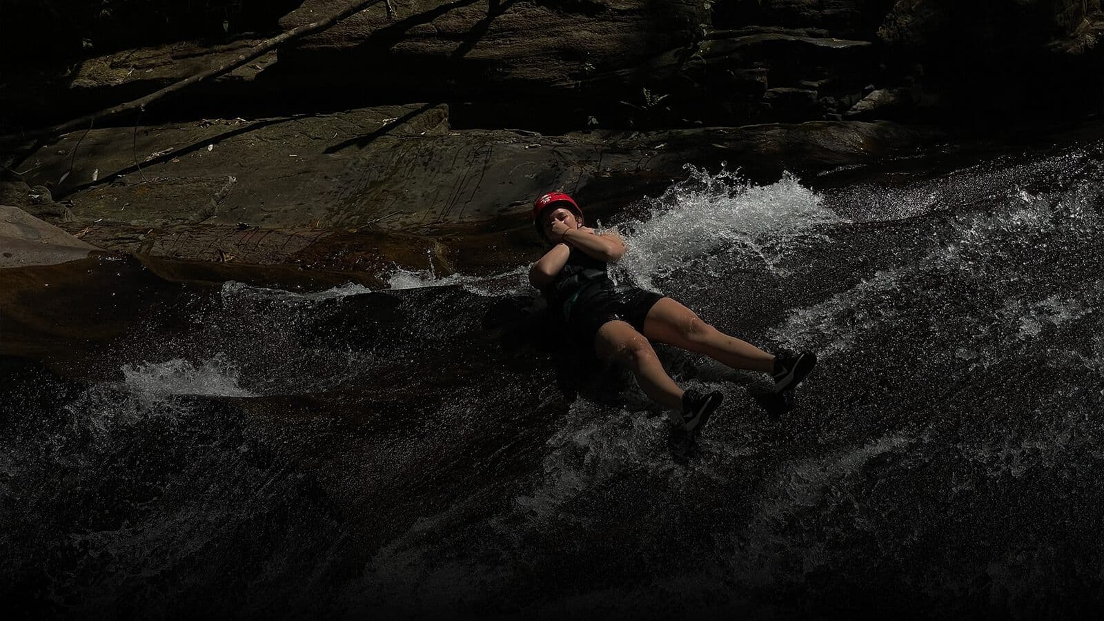 Sliding down a natural rock water slide
