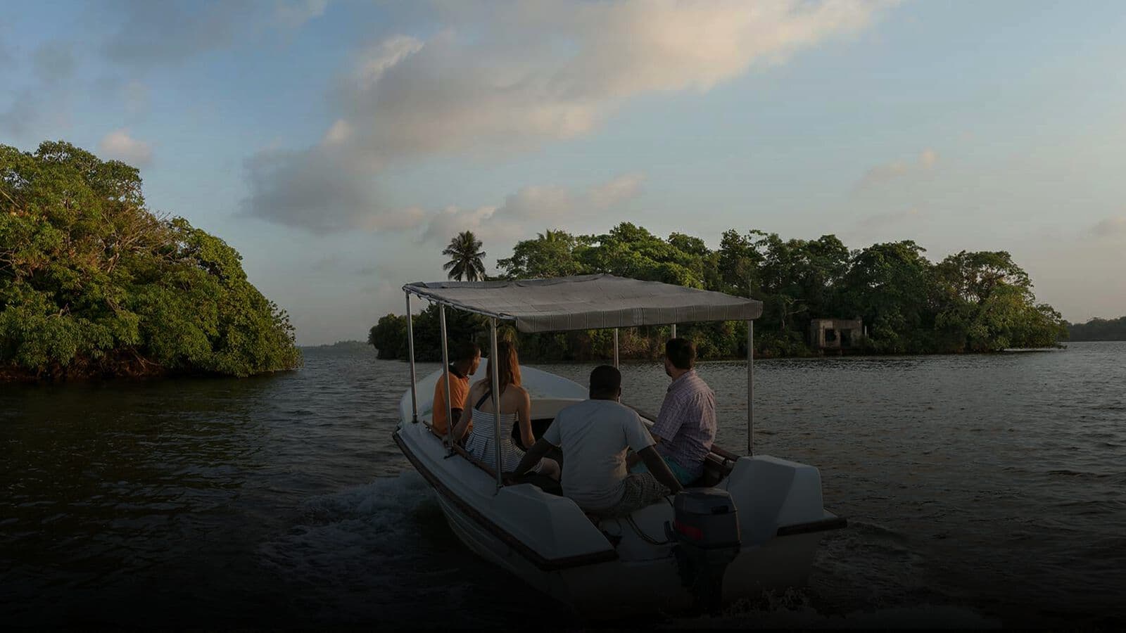 A boat threading the mangroves on the Madu River