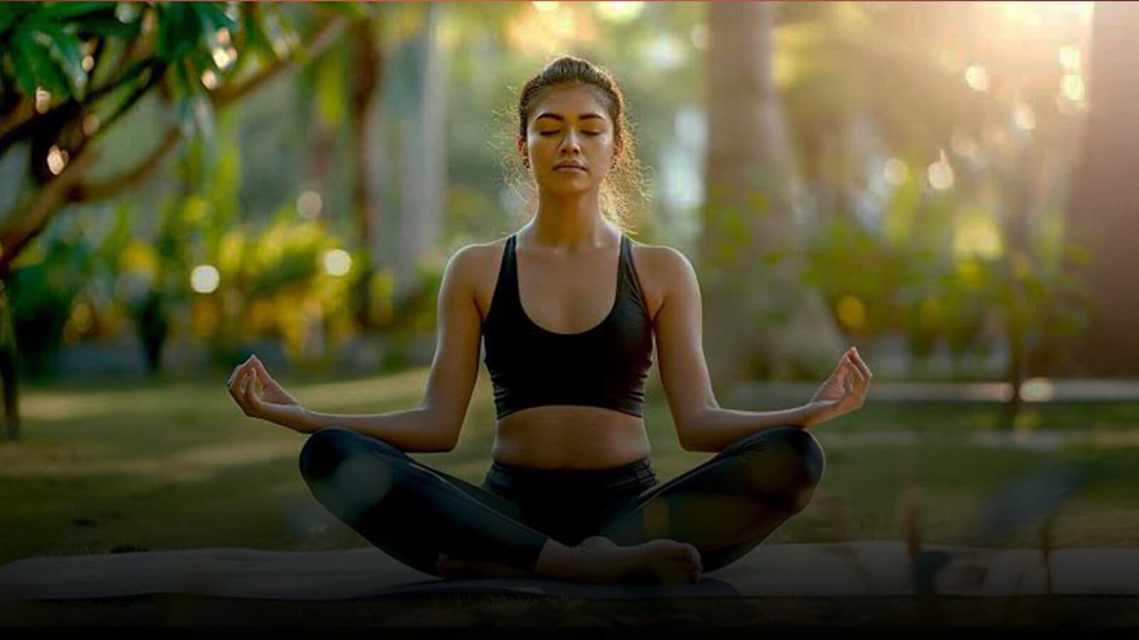 A woman meditating in a garden at sunset