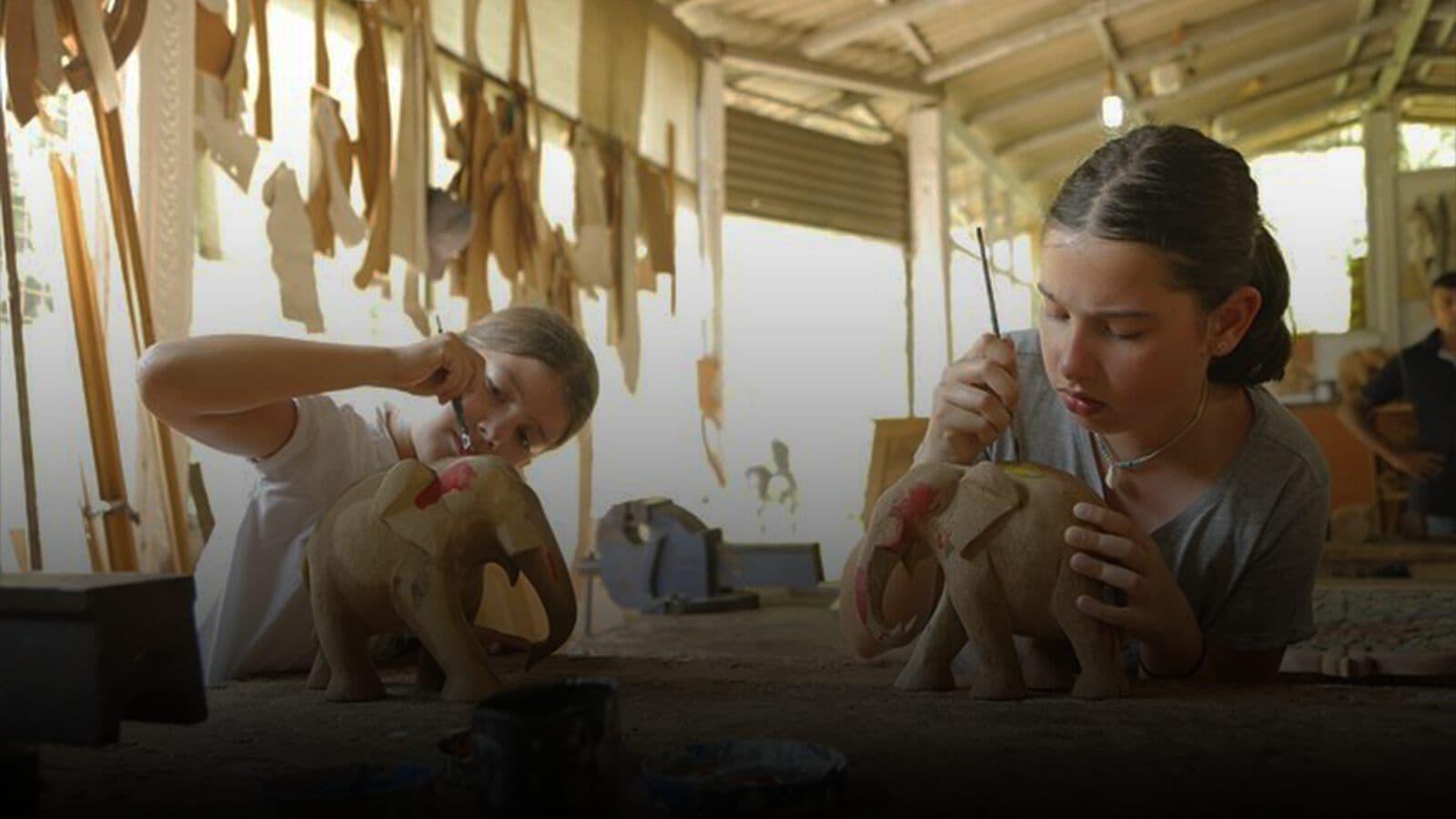 A carved wooden elephant being painted