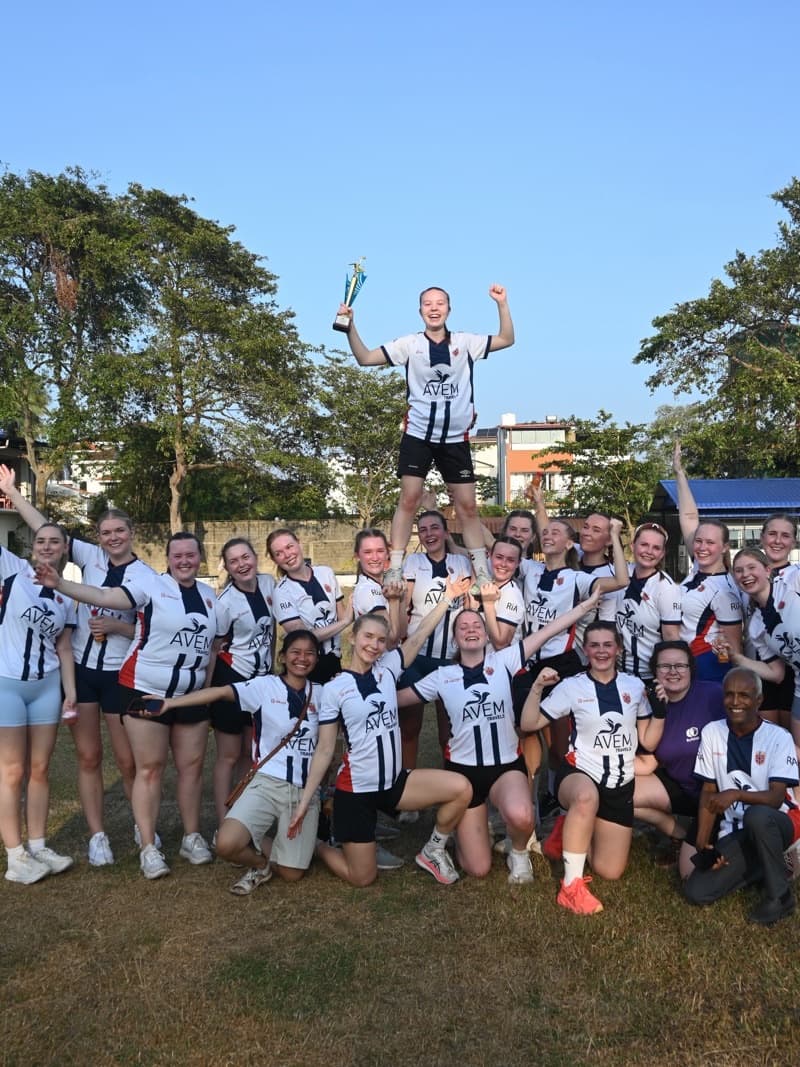 A team in AVEM Travels shirts celebrating with a trophy