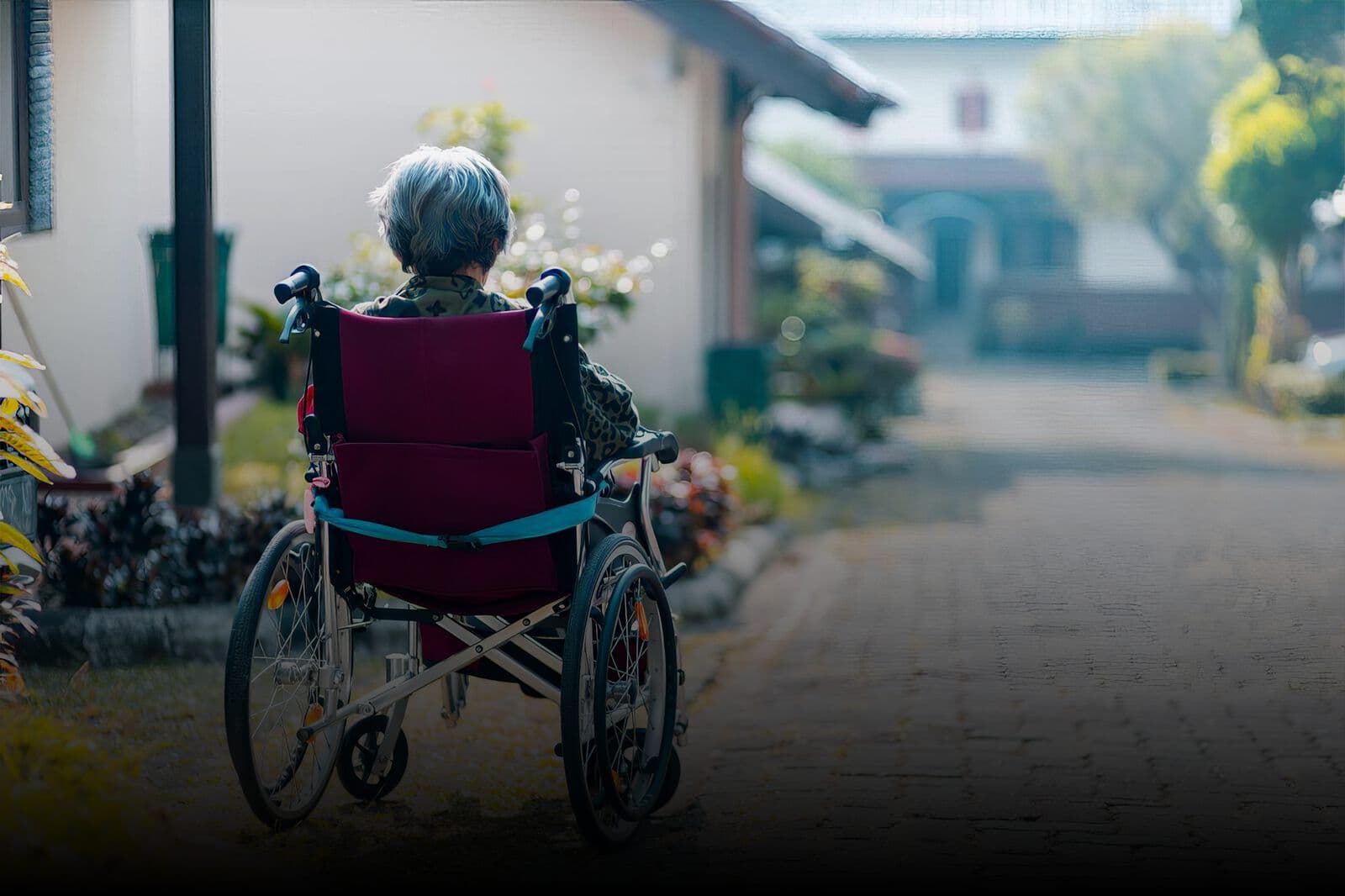 A care worker walking a resident in a wheelchair