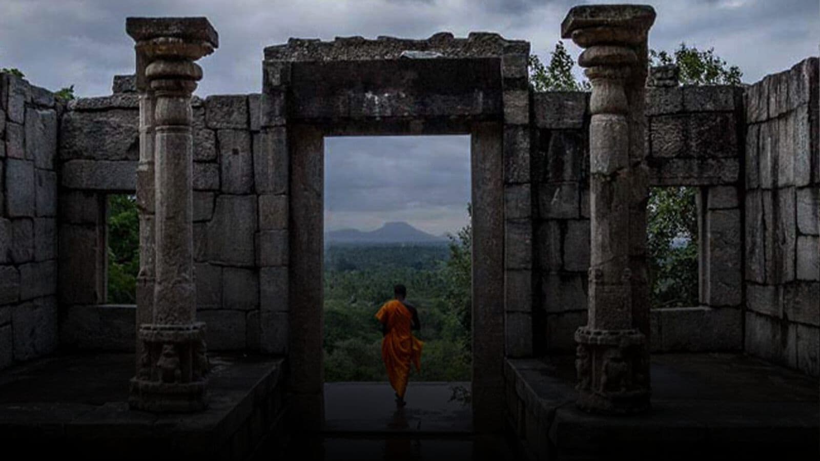 A monk walking through a ruined doorway