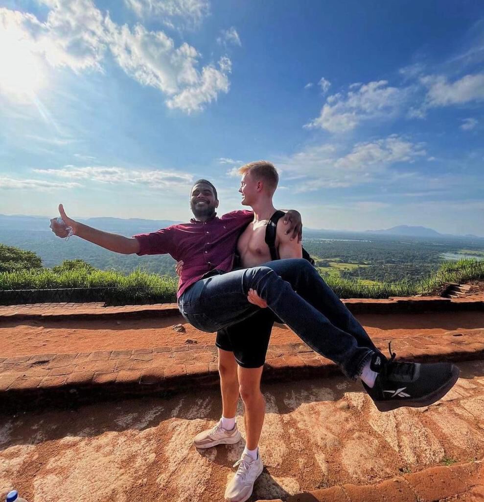Being carried by the guide on the summit, both laughing