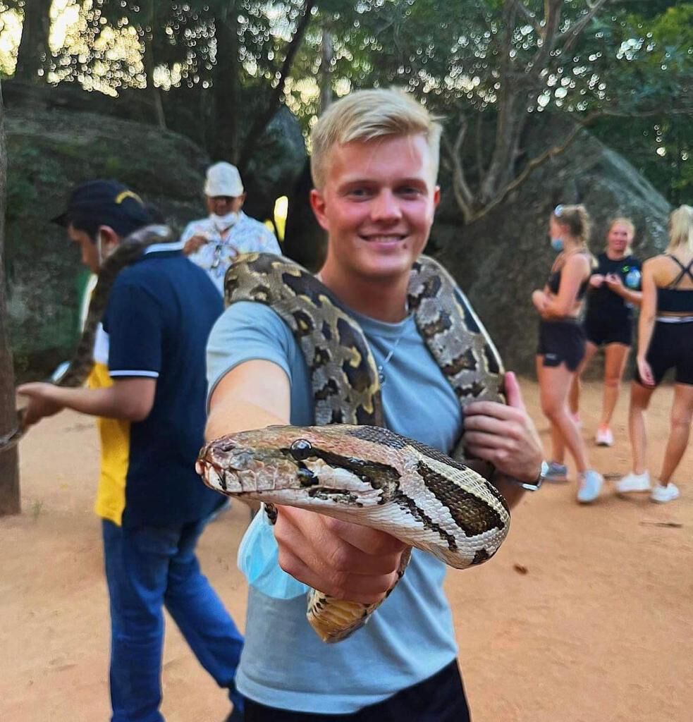 Holding a python at the foot of the rock