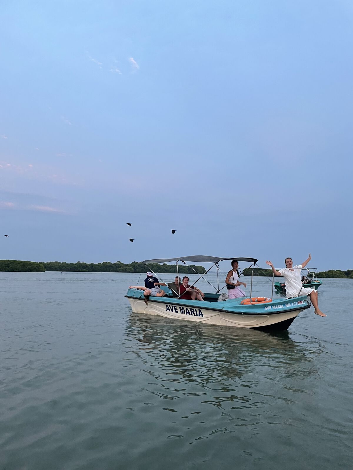 The group on a lagoon boat at dusk