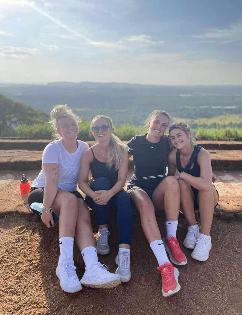 Four travellers resting on a rampart above the plain